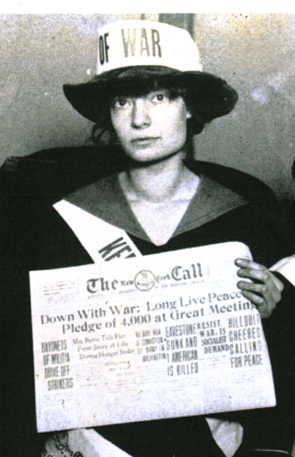 Image of Dorothy Day wearing an anti-war hat and sash