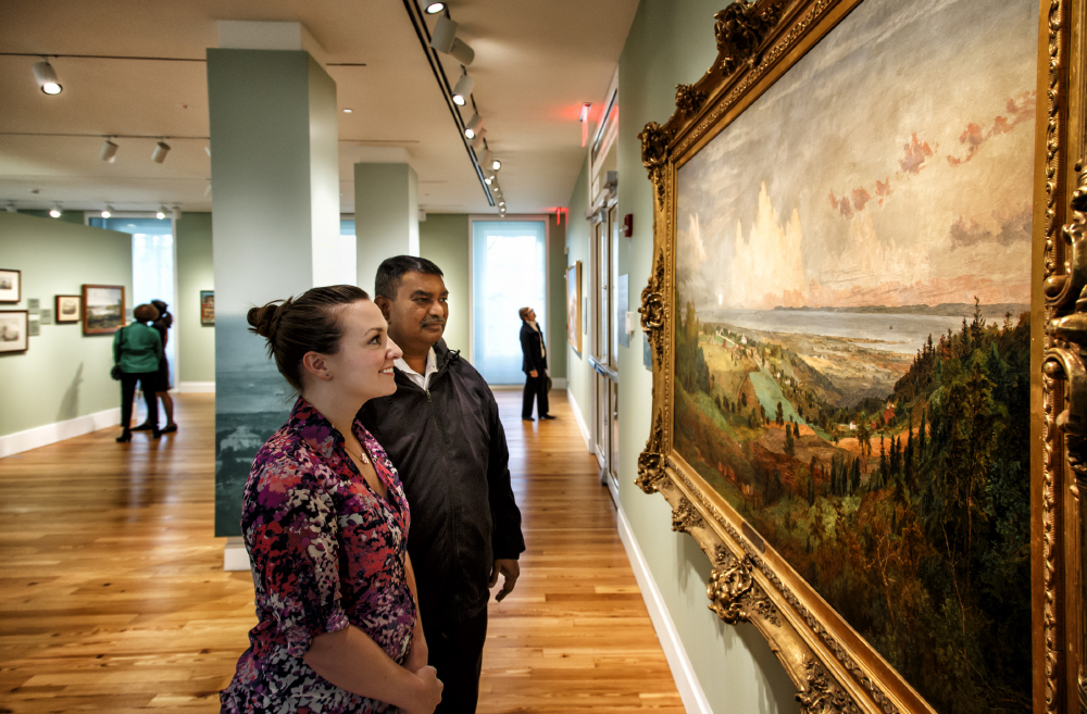 museum visitors looking at a painting on the wall