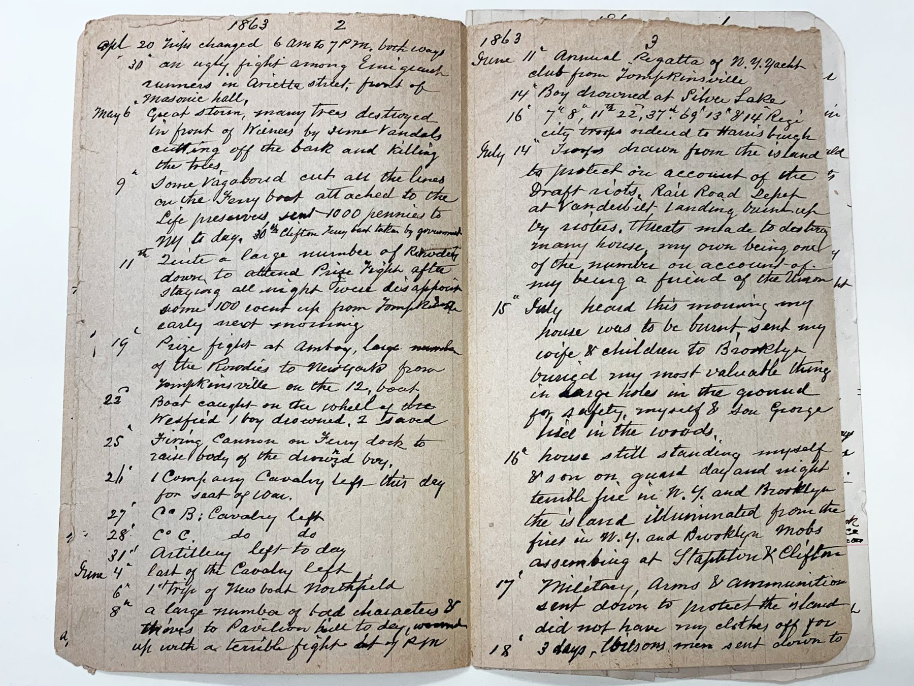 A photograph of an open diary, white pages with black handwriting in script.
