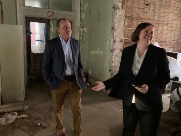 Borough President Vito Fossella with Janice Monger inside building B with exposed brick wall in the background