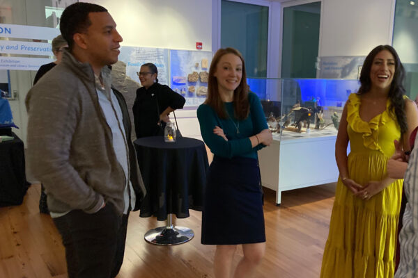 A group of people standing in a museum gallery chatting